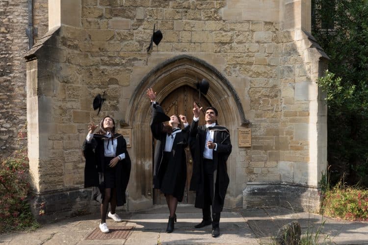 Graduation Day July 2018 - students throw their mortar boards in front of the Library