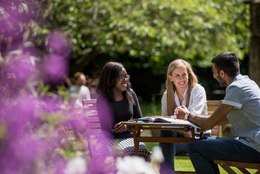 Students chatting at a table in the Broadbent Garden