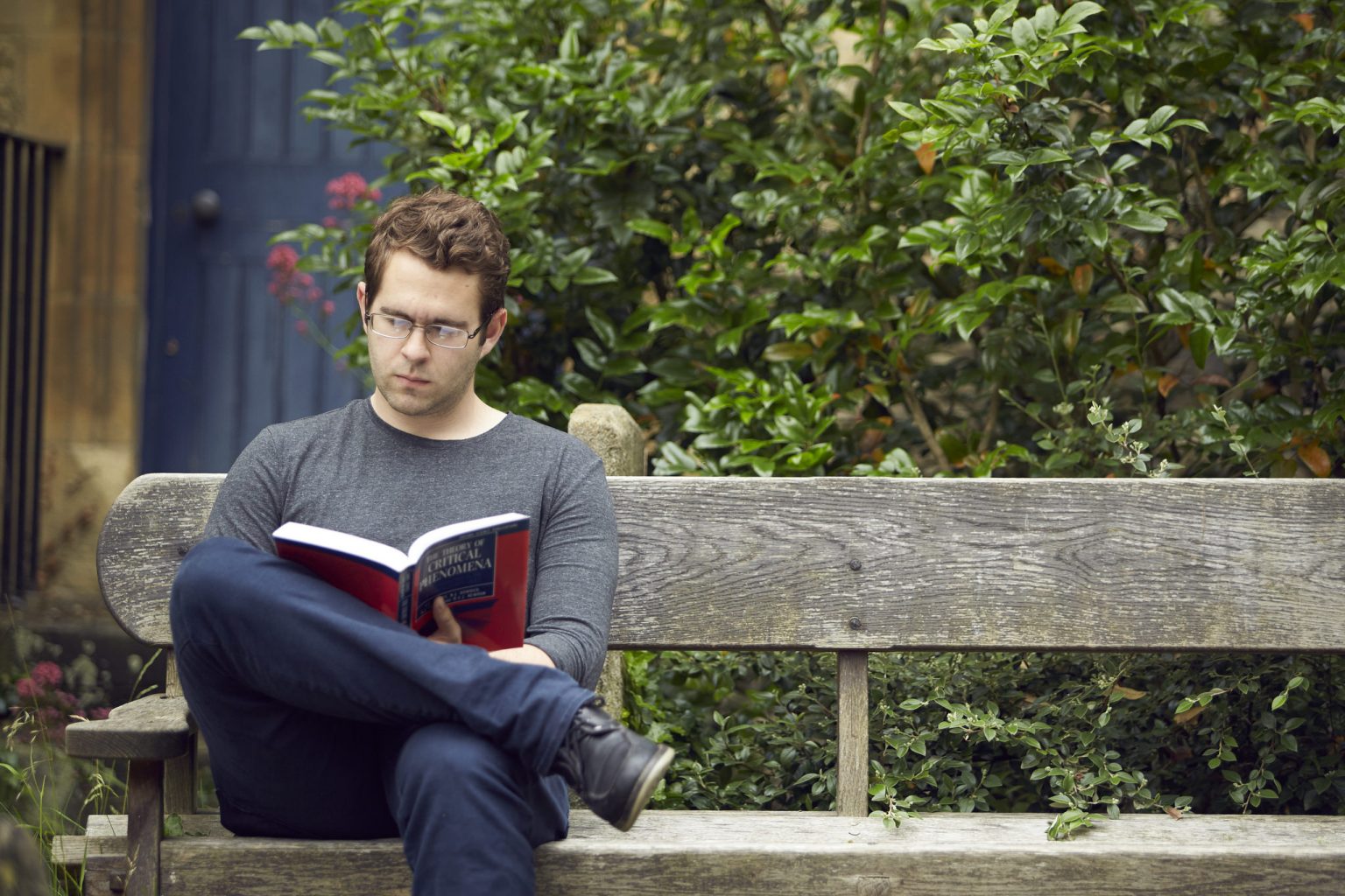 Visiting student Greg reading outside the library in the churchyard
