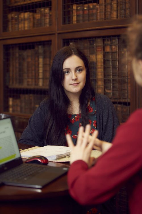 A student and tutor in the College's Old Library