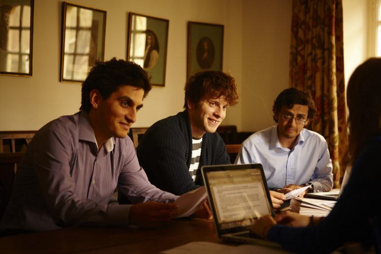 Students in a tutorial with laptop on table
