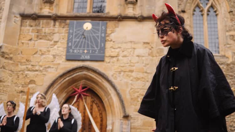 31-1 - Film - Medieval Mysteries Plays - 26th April 2025_1.7.8 A performer dressed as the devil in front of three angels at the Medieval Mystery Plays