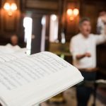 Music book in the Chapel with conductor in background