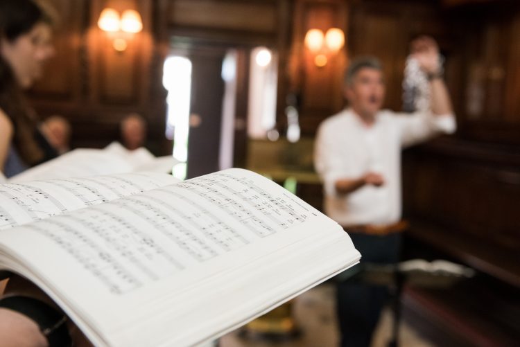 Music book in the Chapel with conductor in background