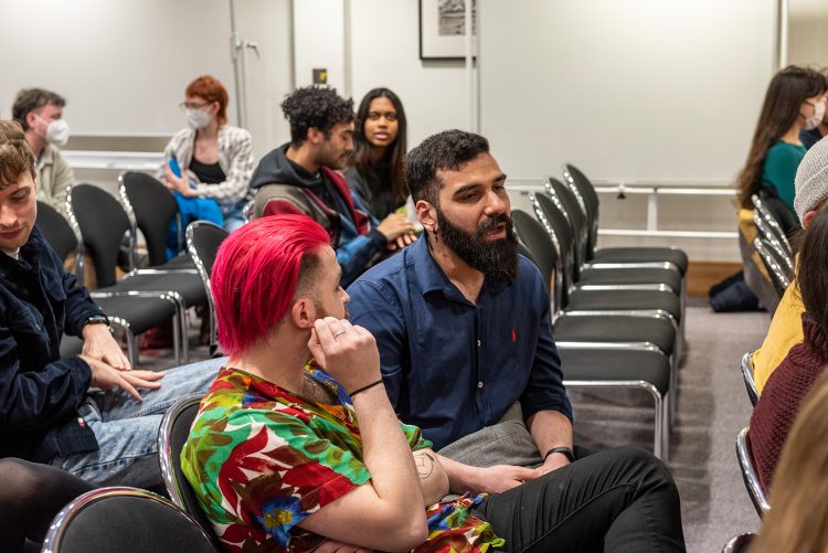 Two audience members discussing LGBTQ rights at the in conversation event with Dan Glass