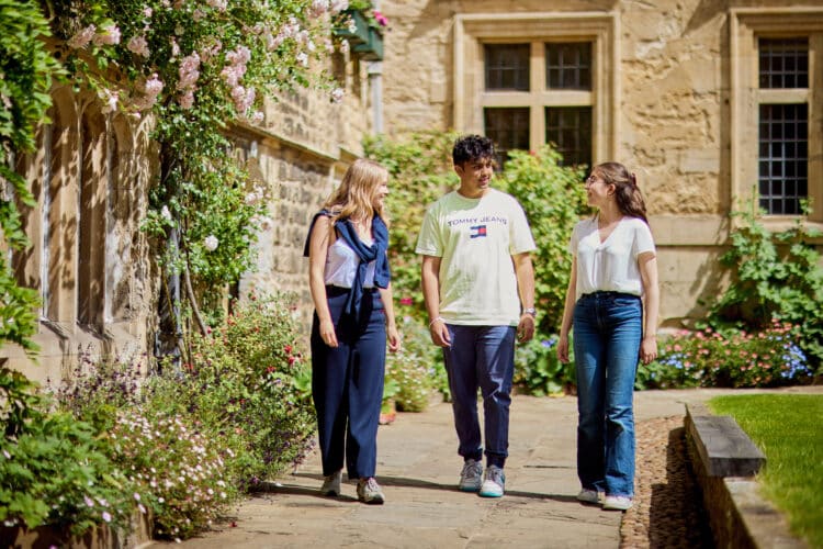 Three undergraduate students walking in the front quad