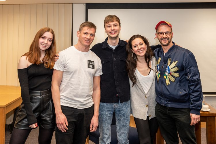 Speakers with audience members in a group photo