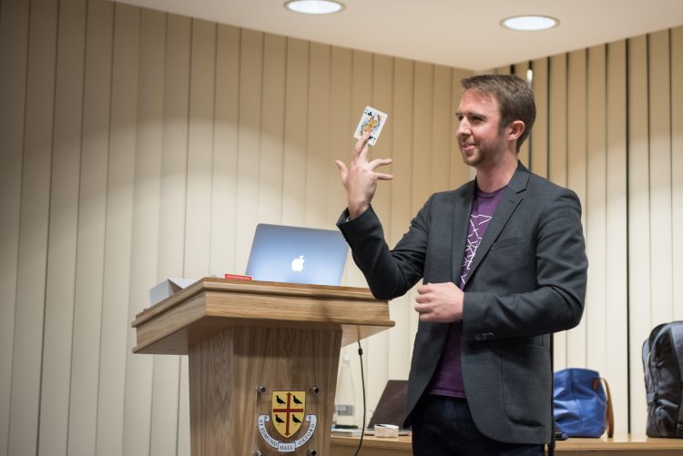 Matthew Thompkins demonstrating a card trick at the Centre for the Creative Brain event