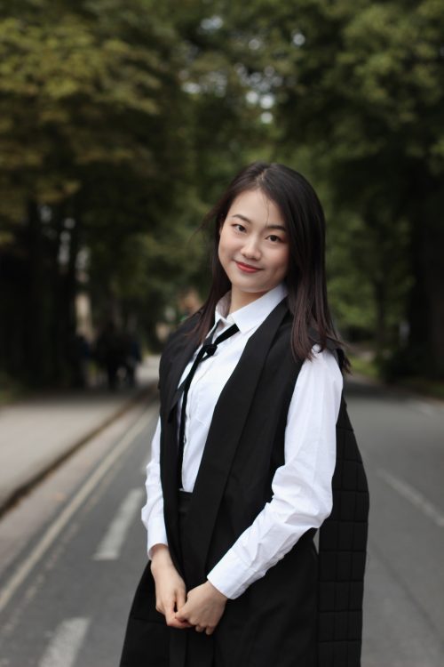 Fanfang standingon a road with wearing her Matriculation clothes.