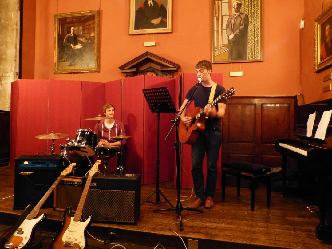 Students playing at an open mic night in College