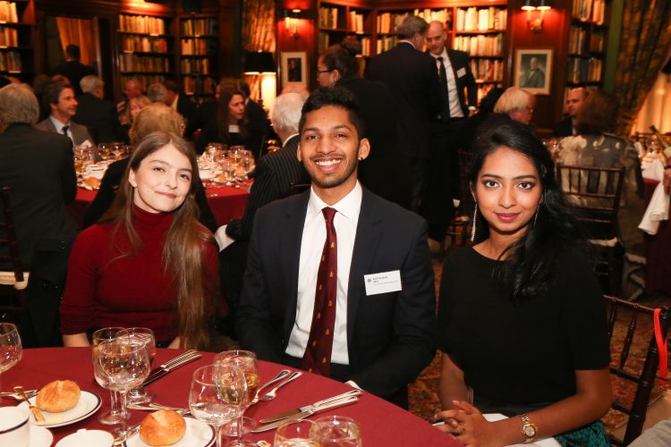 Students sitting on the grass in the College gardens Books in the Teddy Hall library Alumni at the annual New York Dinner