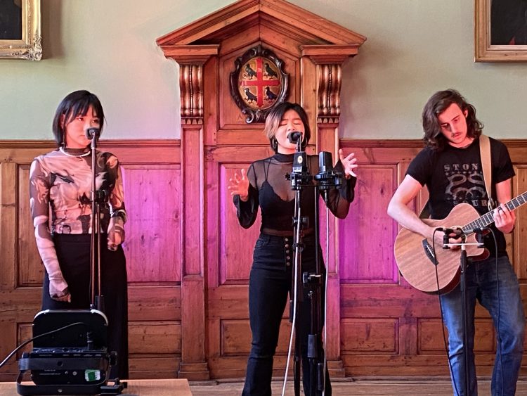 3 students singing on stage at the Trinity Music Concert 2021