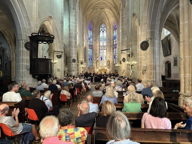 Alumni watching the College Choir in the Église Notre-Dame de Noyers