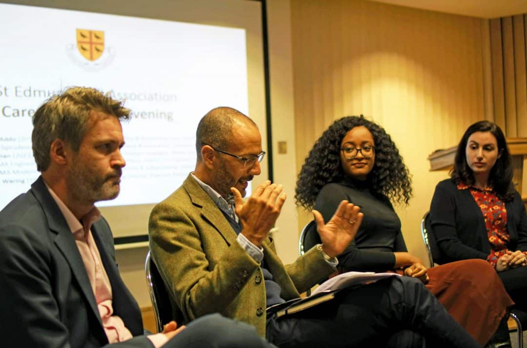 A group of alumni seated in front of a projector screen, giving advice to Teddy Hall students at a Careers Advisory Evening