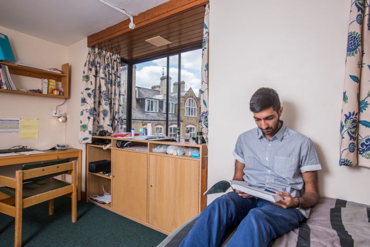 A student reading in his room in the Emden building