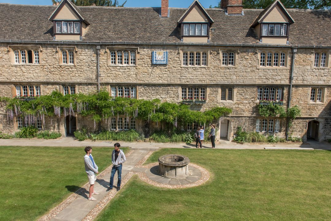 Students chatting in the Front Quad by the well