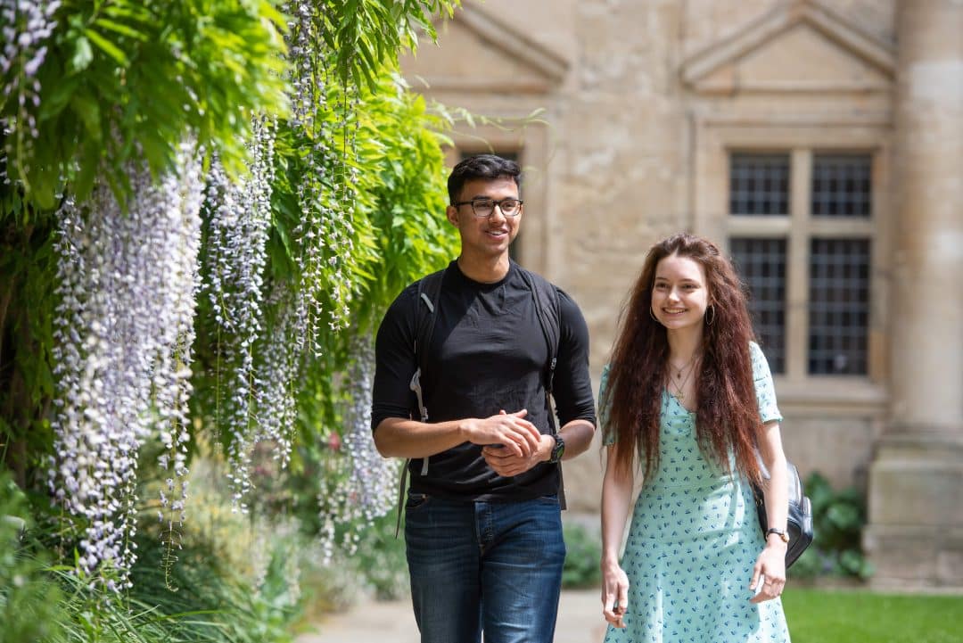 Students walking next to the Wisteria in the Front Quad