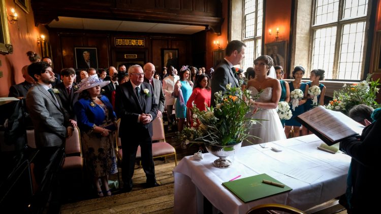 A couple exchange wedding vows in the Old Dining Hall - photo by Mario Mage