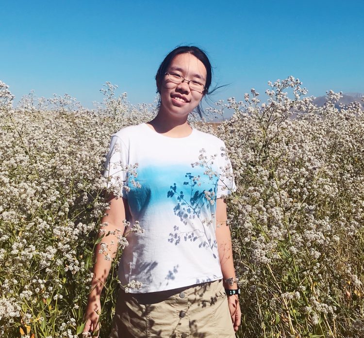 Ziqi standing in a field of flowers.